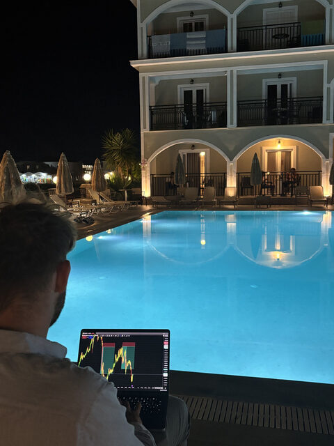 Peer arbeitet abends am Pool an seinem Trading-Setup